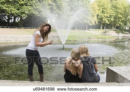 Female friends using cell phone View Large Photo Image Stock Photo - Female friends using cell phone. Fotosearch