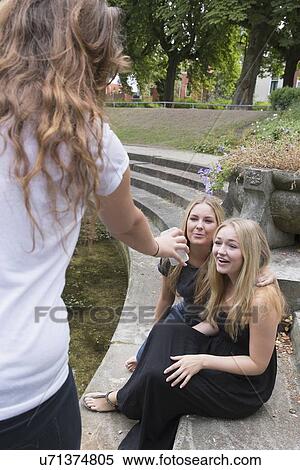 Female friends using cell phone View Large Photo Image Stock Photography - Female friends using cell phone. Fotosearch