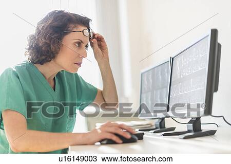 Stock Image - Female technician working on computer. Fotosearch
