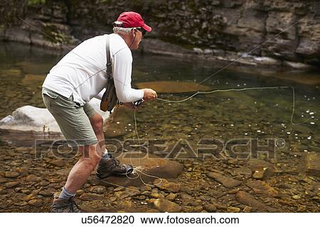 Fisherman on riverbank View Large Photo Image Stock Image - Fisherman on riverbank. Fotosearch