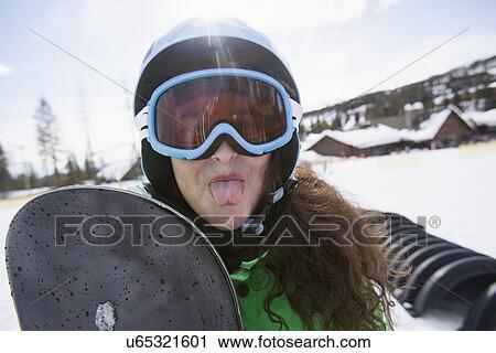 Girl with snowboard sticking out her tongue View Large Photo Image Stock Image - Girl with snowboard sticking out her tongue. Fotosearch