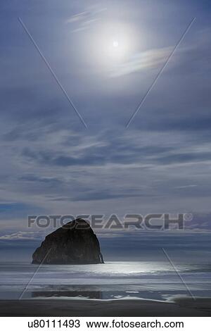 Stock Image - Haystack Rock at moonset. Fotosearch