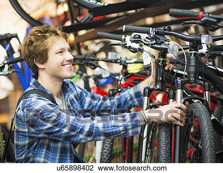 Man choosing bike in bike shop View Large Photo Image Stock Image - Man choosing bike in bike shop. Fotosearch