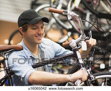 Man fixing bike in bike shop View Large Photo Image Stock Image - Man fixing bike in bike shop. Fotosearch