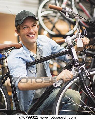 Man fixing bike in bike shop View Large Photo Image Stock Image - Man fixing bike in bike shop. Fotosearch