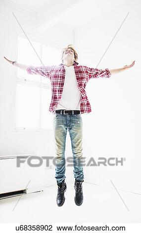 Man jumping in room View Large Photo Image Stock Image - Man jumping in room. Fotosearch