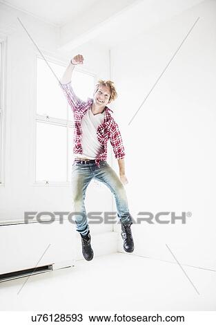 Man jumping in room View Large Photo Image Stock Image - Man jumping in room. Fotosearch