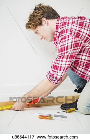 Man measuring baseboard View Large Photo Image Stock Photo - Man measuring baseboard. Fotosearch