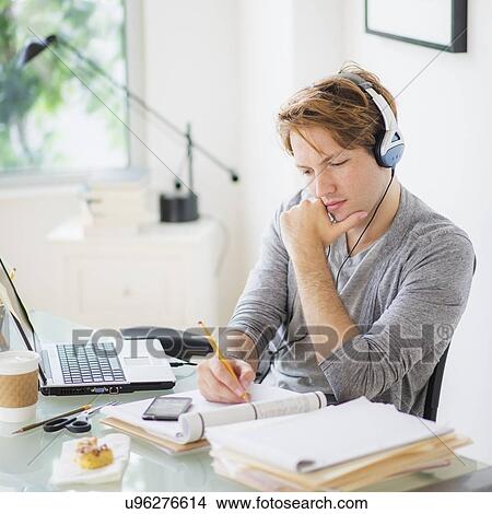Picture - Man multi-tasking in home office. Fotosearch