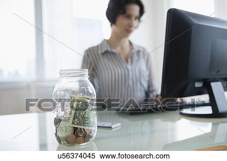 Money in jar on businesswoman's desk View Large Photo Image Stock Photography - Money in jar on businesswoman's desk. Fotosearch