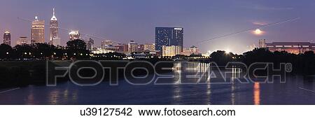 Stock Image - Moon rising over city. Fotosearch