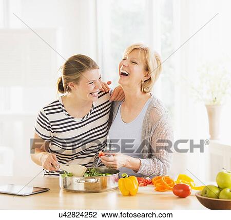 Mother and adult daughter cooking together View Large Photo Image Stock Image - Mother and adult daughter cooking together. Fotosearch