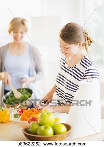 Mother and adult daughter cooking together View Large Photo Image Stock Image - Mother and adult daughter cooking together. Fotosearch