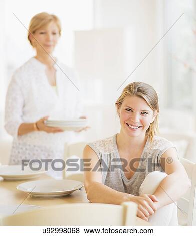 Mother and adult daughter in dining room View Large Photo Image Stock Photo - Mother and adult daughter in dining room. Fotosearch