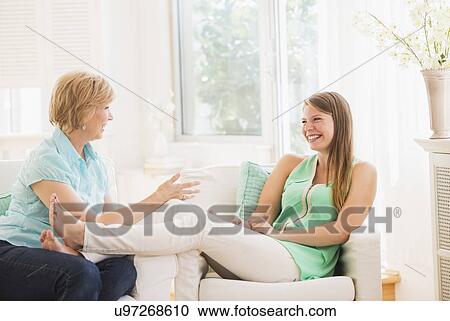 Mother and adult daughter sitting on sofa and talking View Large Photo Image Stock Image - Mother and adult daughter sitting on sofa and talking. Fotosearch