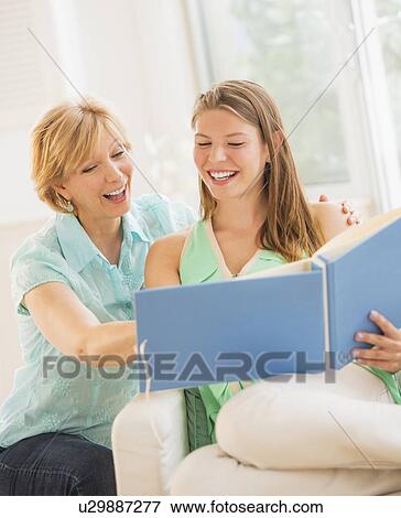 Mother and adult daughter watching photo album View Large Photo Image Stock Photo - Mother and adult daughter watching photo album. Fotosearch
