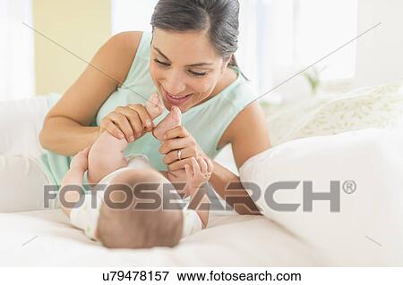 Mother and baby (2-5 months) lying on bed View Large Photo Image Stock Photo - Mother and baby (2-5 months) lying on bed. Fotosearch