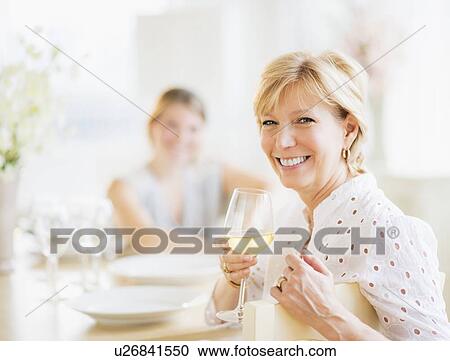 Mother drinking wine during dinner, out-of-focus daughter in background View Large Photo Image Stock Image - Mother drinking wine during dinner, out-of-focus daughter in background. Fotosearch