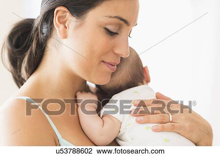 Stock Image - Mother holding baby boy (2-5 months). Fotosearch
