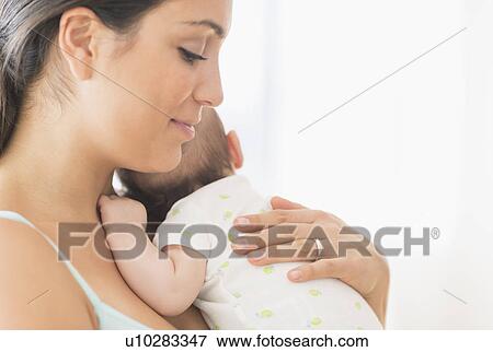 Stock Photo - Mother holding baby boy (2-5 months). Fotosearch