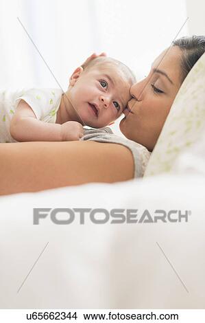 Picture - Mother kissing baby boy (2-5 months). Fotosearch