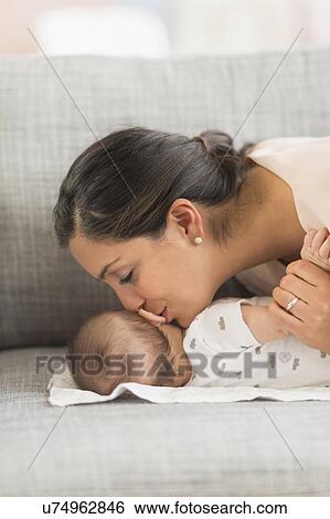 Stock Photograph - Mother kissing baby boy (2-5 months) . Fotosearch