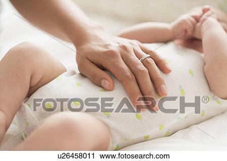 Mother massaging belly of baby boy (2-5 months) View Large Photo Image Stock Image - Mother massaging belly of baby boy (2-5 months). Fotosearch