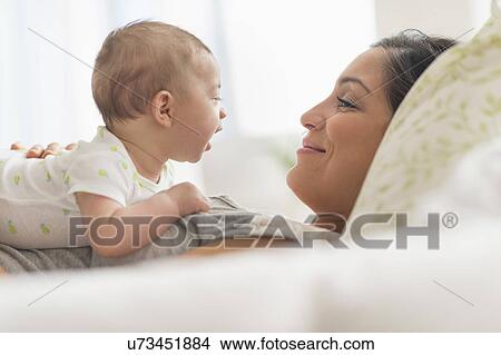 Picture - Mother playing with baby boy (2-5 months). Fotosearch