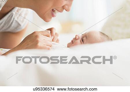 Picture - Mother playing with baby boy (2-5 months). Fotosearch