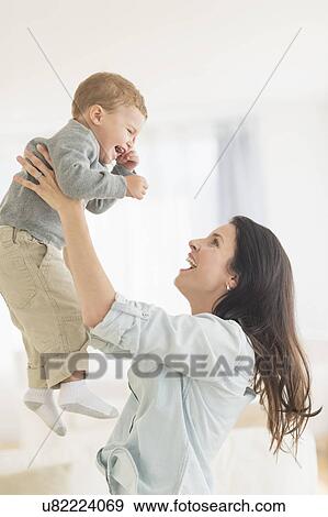 Stock Photo - Mother playing with son (12-17 months). Fotosearch
