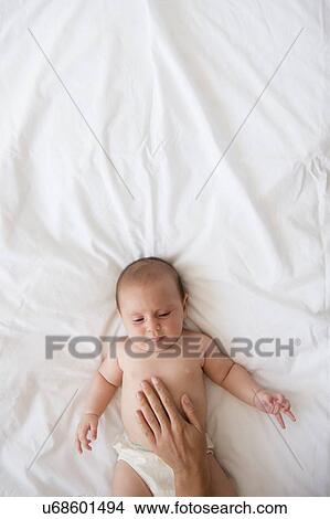 Mother touching belly of baby girl (2-5 months) View Large Photo Image Picture - Mother touching belly of baby girl (2-5 months). Fotosearch