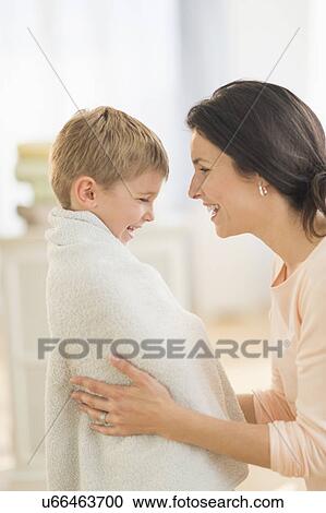 Stock Image - Mother with son (6-7) wrapped in towel. Fotosearch