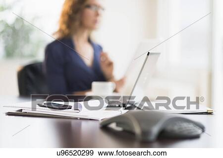 Office desk with defocused businesswoman View Large Photo Image Stock Photo - Office desk with defocused businesswoman. Fotosearch
