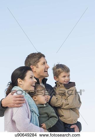 Parents with kids (12-17 months, 6-7) under blue sky View Large Photo Image Picture - Parents with kids (12-17 months, 6-7) under blue sky. Fotosearch