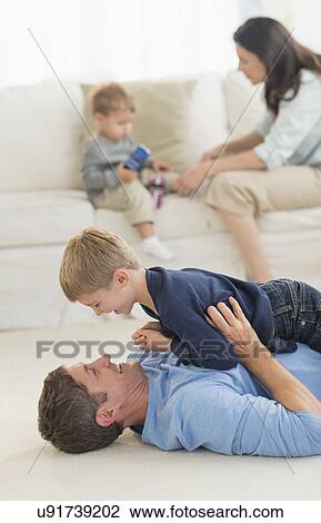 Stock Image - Parents with kids (12-17 months, 6-7) playing at home. Fotosearch