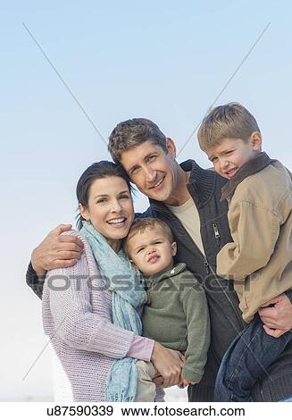 Stock Photo - Parents with kids (12-17 months, 6-7) under blue sky. Fotosearch