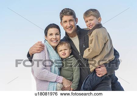 Stock Photograph - Parents with kids (12-17 months, 6-7) under blue sky. Fotosearch
