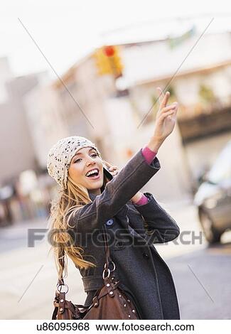 Portrait of blond woman hailing cab View Large Photo Image Stock Photo - Portrait of blond woman hailing cab. Fotosearch