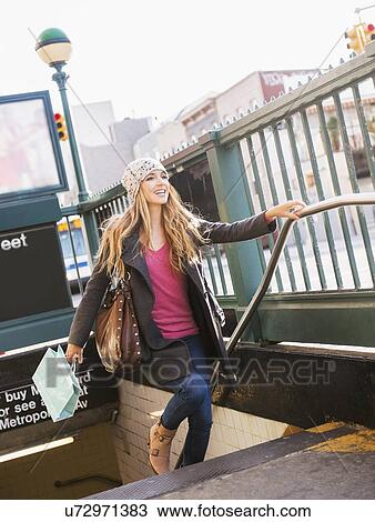 Stock Image - Portrait of blond woman leaving subway station. Fotosearch