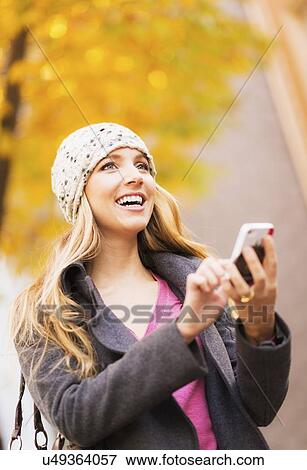 Stock Photo - Portrait of blond woman using cell phone. Fotosearch