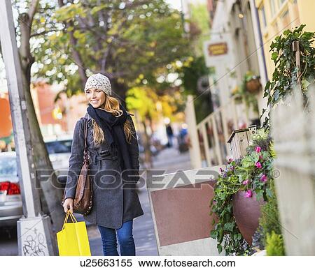 Portrait of blond woman walking on sidewalk View Large Photo Image Stock Photography - Portrait of blond woman walking on sidewalk. Fotosearch