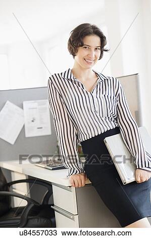 Stock Image - Portrait of business woman in office. Fotosearch
