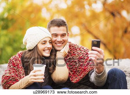 Portrait of couple in Central Park taking photo of themselves View Large Photo Image Stock Image - Portrait of couple in Central Park taking photo of themselves. Fotosearch