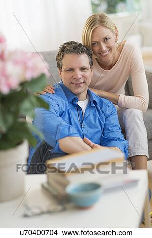 Portrait of couple sitting on sofa View Large Photo Image Picture - Portrait of couple sitting on sofa. Fotosearch