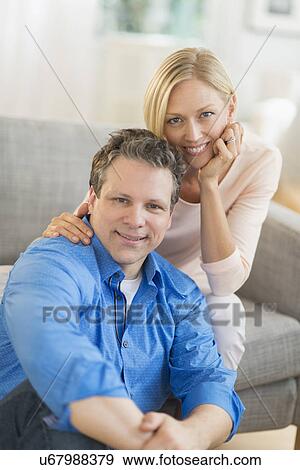 Portrait of couple sitting on sofa View Large Photo Image Stock Photo - Portrait of couple sitting on sofa. Fotosearch