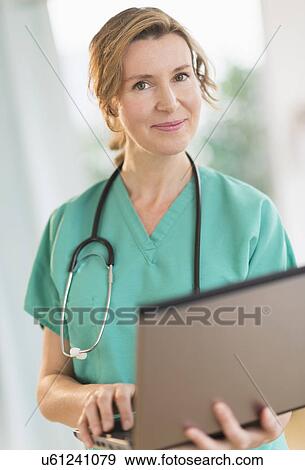 Portrait of female doctor using laptop View Large Photo Image Stock Photo - Portrait of female doctor using laptop. Fotosearch