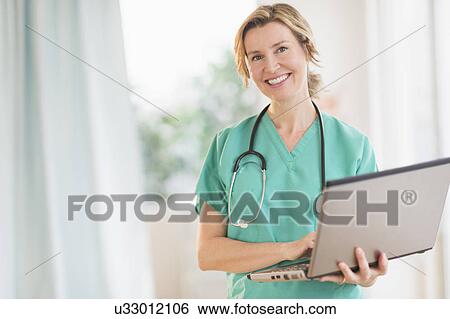 Portrait of female doctor using laptop View Large Photo Image Stock Photograph - Portrait of female doctor using laptop. Fotosearch