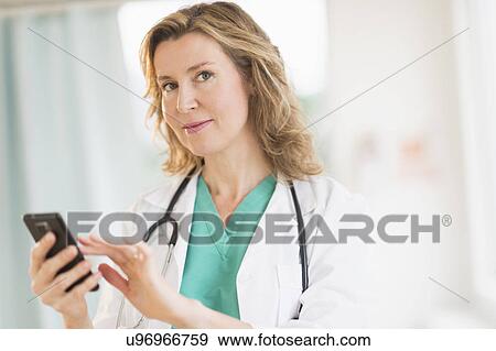 Stock Photo - Portrait of female doctor using phone. Fotosearch
