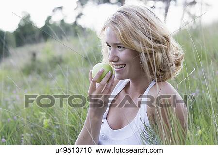 Portrait of happy woman eating apple View Large Photo Image Stock Image - Portrait of happy woman eating apple. Fotosearch