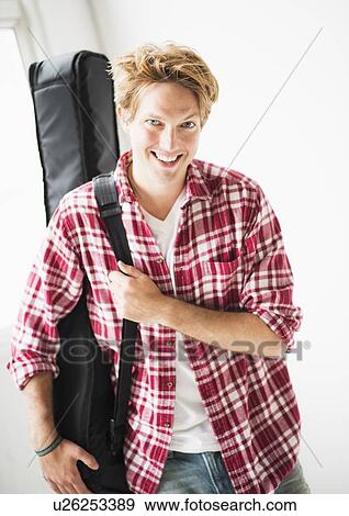 Portrait of man carrying guitar bag View Large Photo Image Stock Photo - Portrait of man carrying guitar bag. Fotosearch